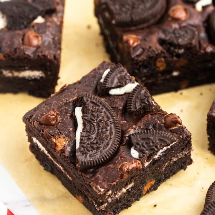 Squares of Oreo brownies placed on parchment paper