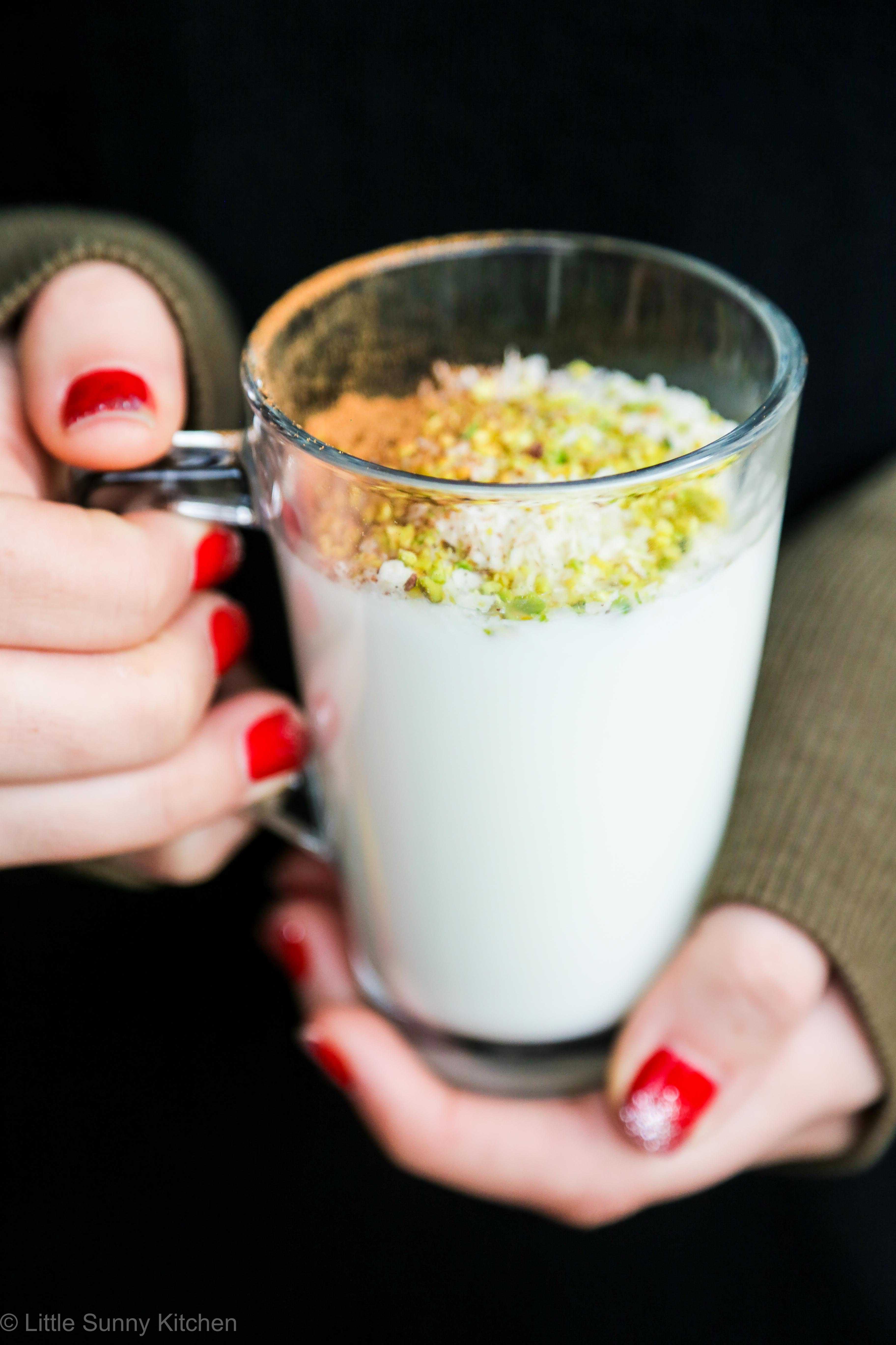 Girl holding a glass mug filled with sahlab