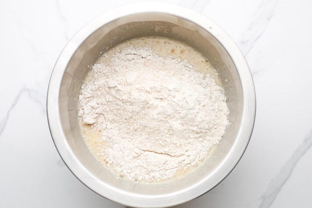 Bowl with flour mixture added to wet banana bread ingredients before mixing.