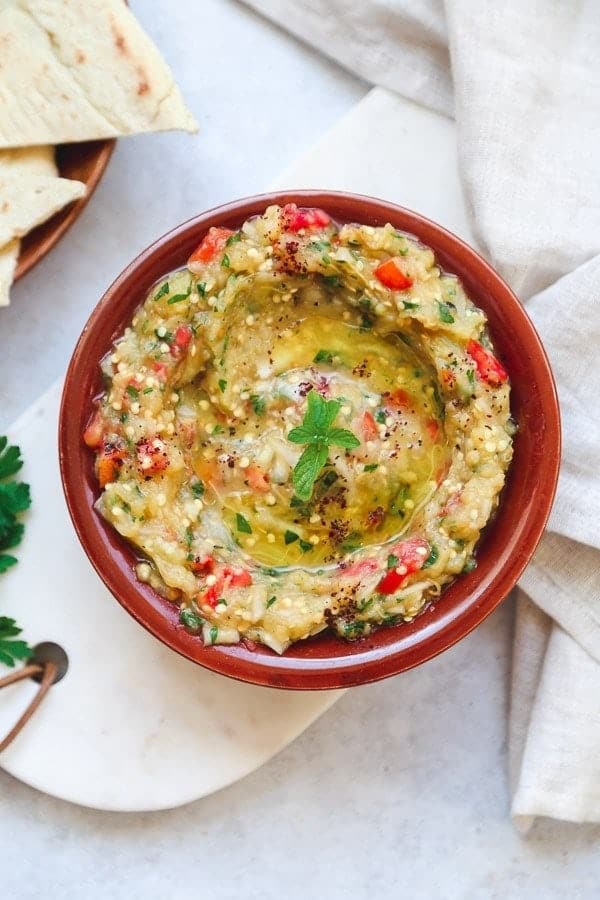 Baba ganoush in a traditional plate, with pita bread on the side