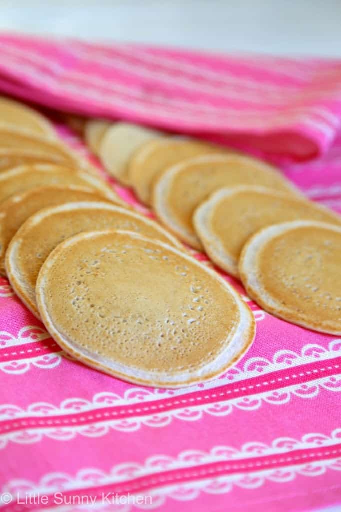 Atayef stacked on a tea towel to keep them from drying