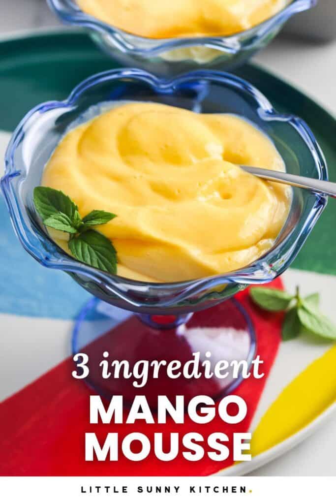 A blue glass dessert cup filled with creamy mango mousse, garnished with fresh mint, with text overlay that reads "3 ingredient Mango Mousse" and "Little Sunny Kitchen."