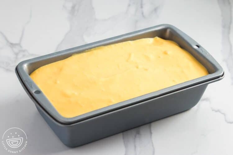 Mango mousse poured into a loaf pan, ready to be chilled