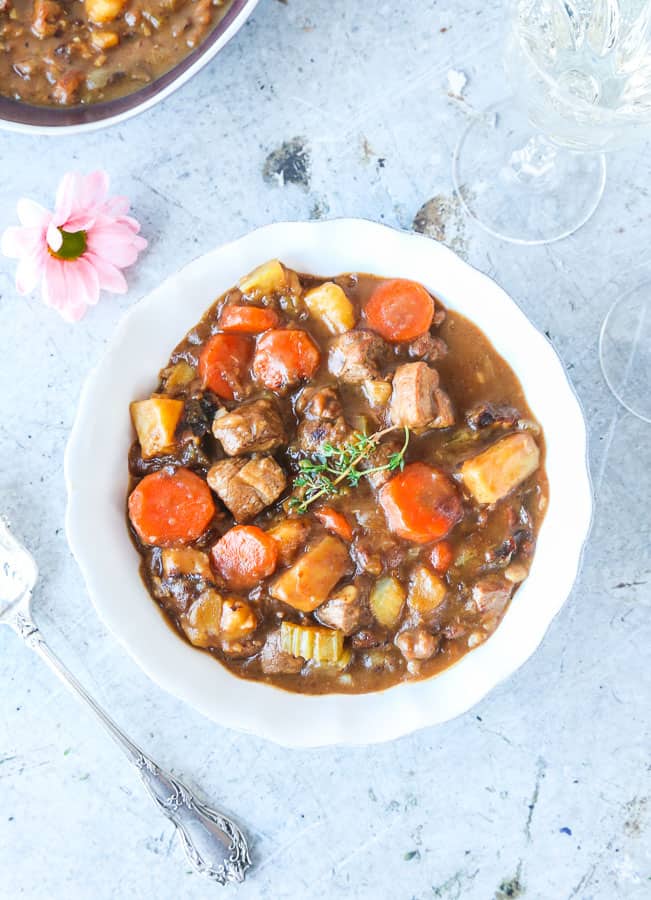 A bowl of lamb stew with carrots, potatoes, and celery.