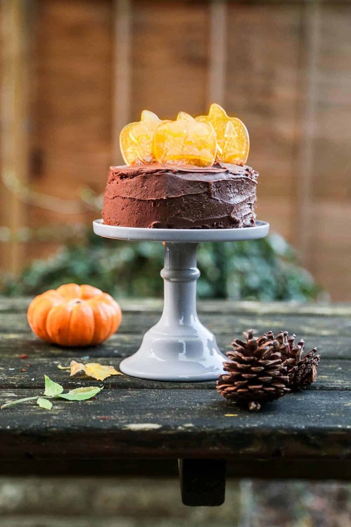 Vegan chocolate cake decorated with homemade pumpkin shaped candy