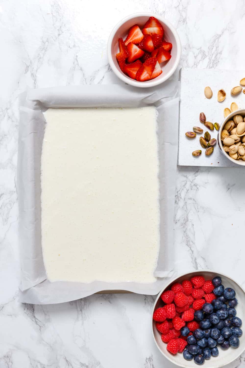Overhead shot of yogurt spread on a rimmed sheet pan lined with parchment paper