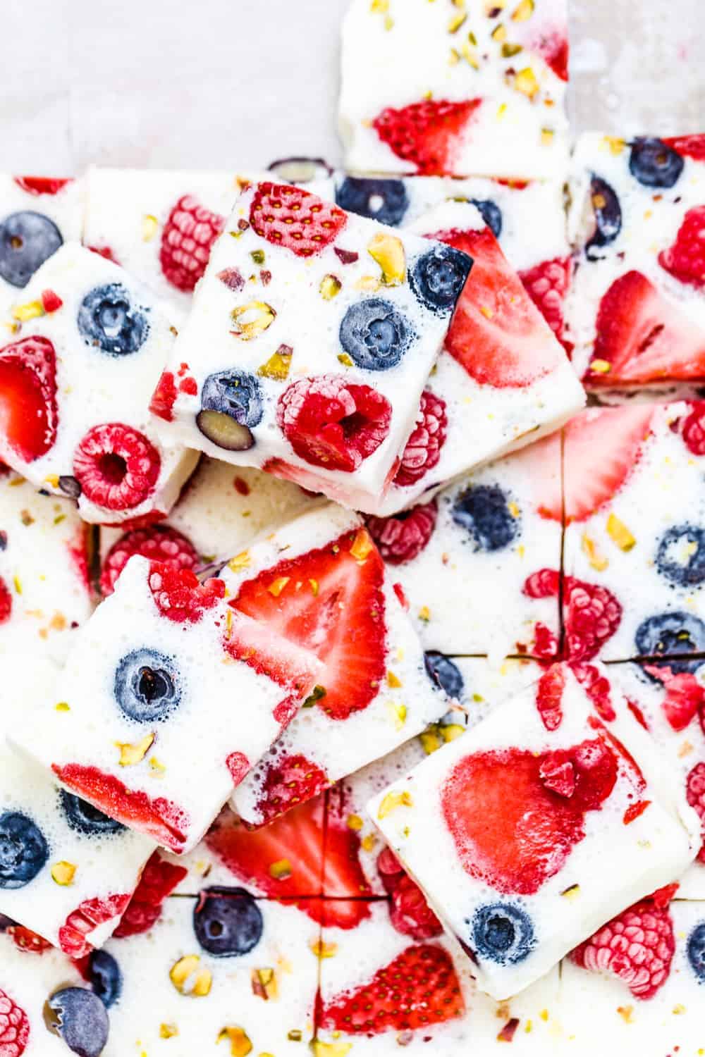 Overhead shot of squares of berry frozen yogurt bark stacked on each other