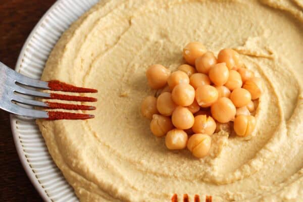 Decorating hummus with paprika garnish using a spoon