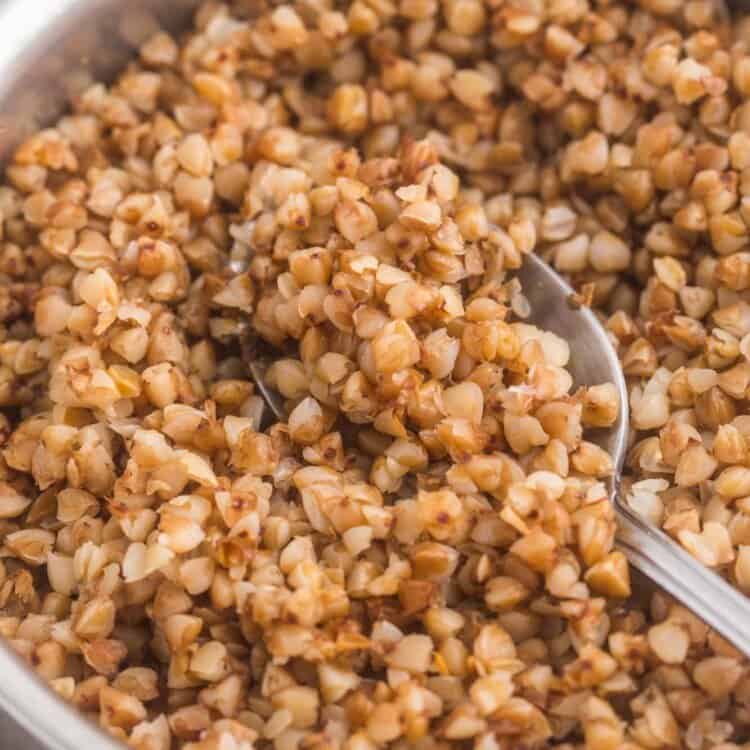 Cooked buckwheat in a saucepan with a spoon