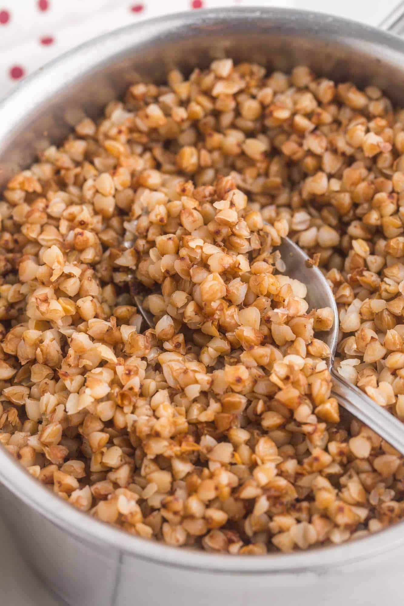 Cooked buckwheat in a saucepan with a spoon