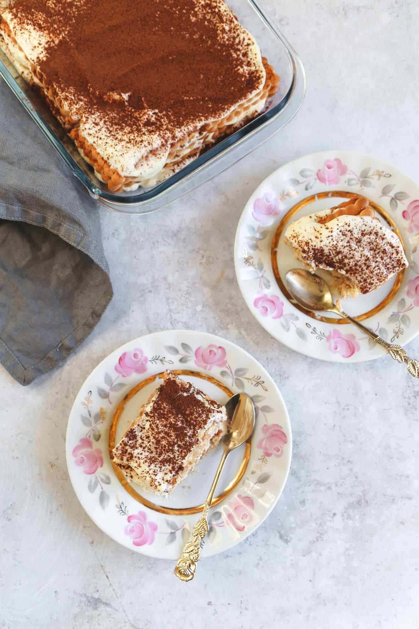 Overhead shot of slices of nescafe cake served in small cake plates, and the cake in a pyrex glass dish.