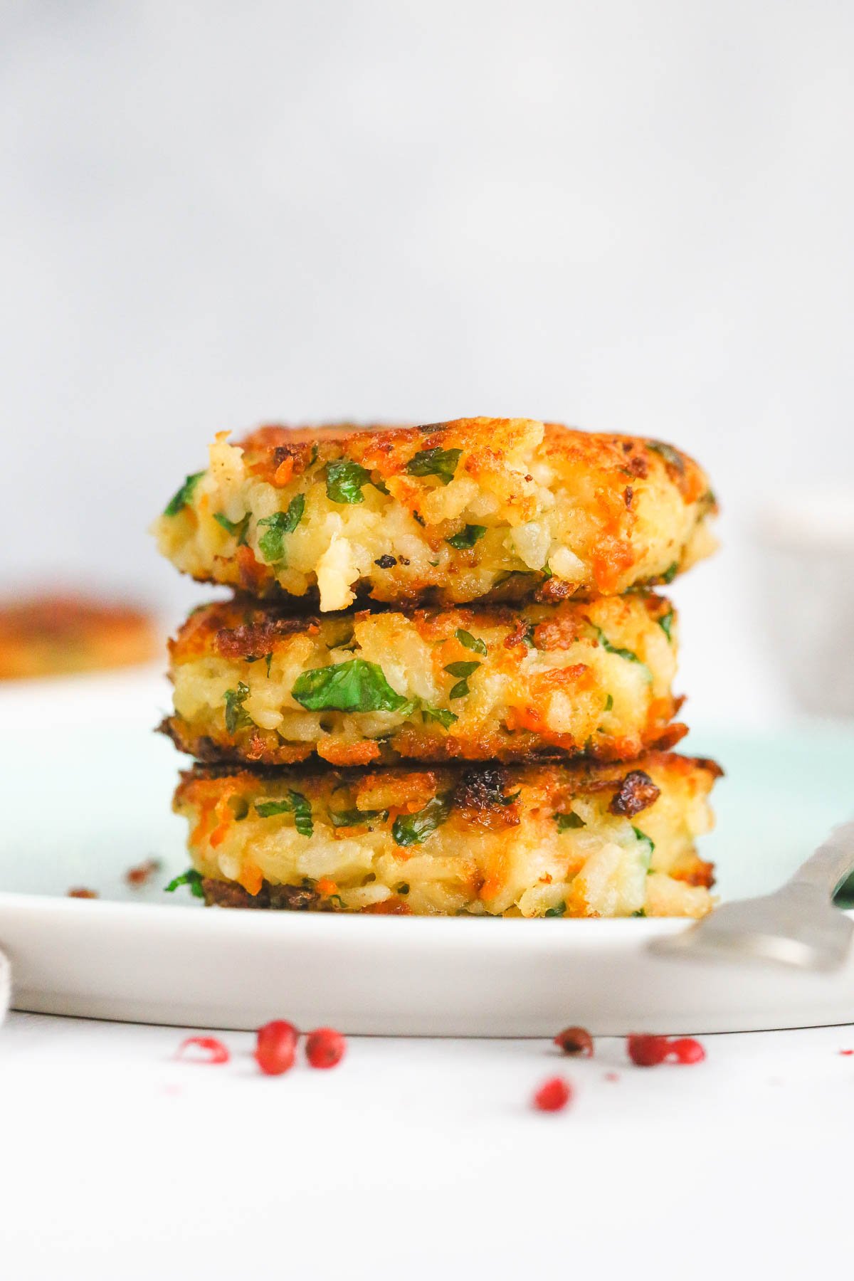 vegan potato cakes with carrot and rice stacked on a plate