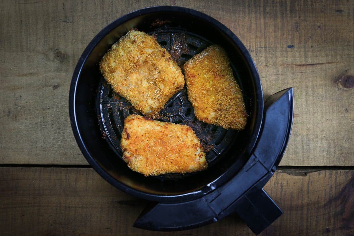 3 pieces of fish that are breaded and air fried, in the air fryer basket.