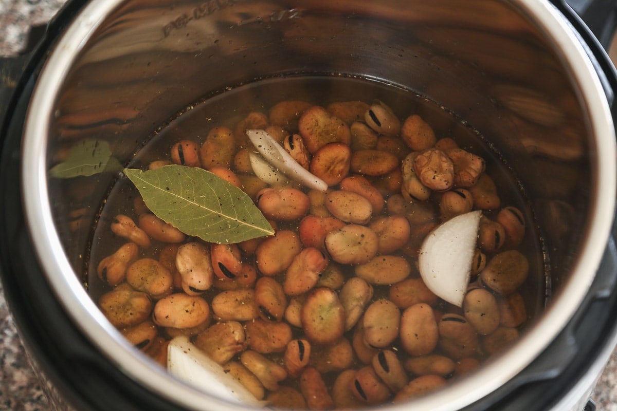 Fava beans in the instant pot with a bay leaf, onion and cumin