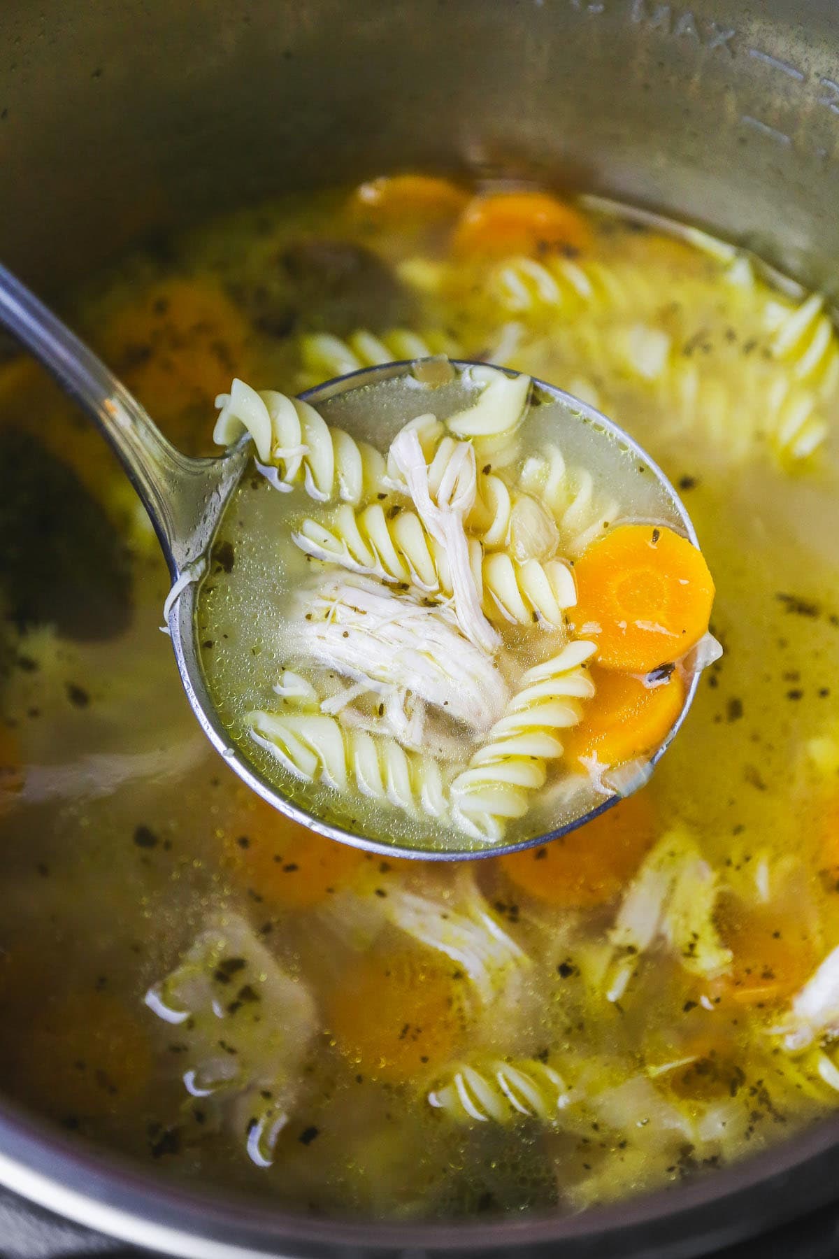 comforting instant pot chicken noodle soup in a ladle