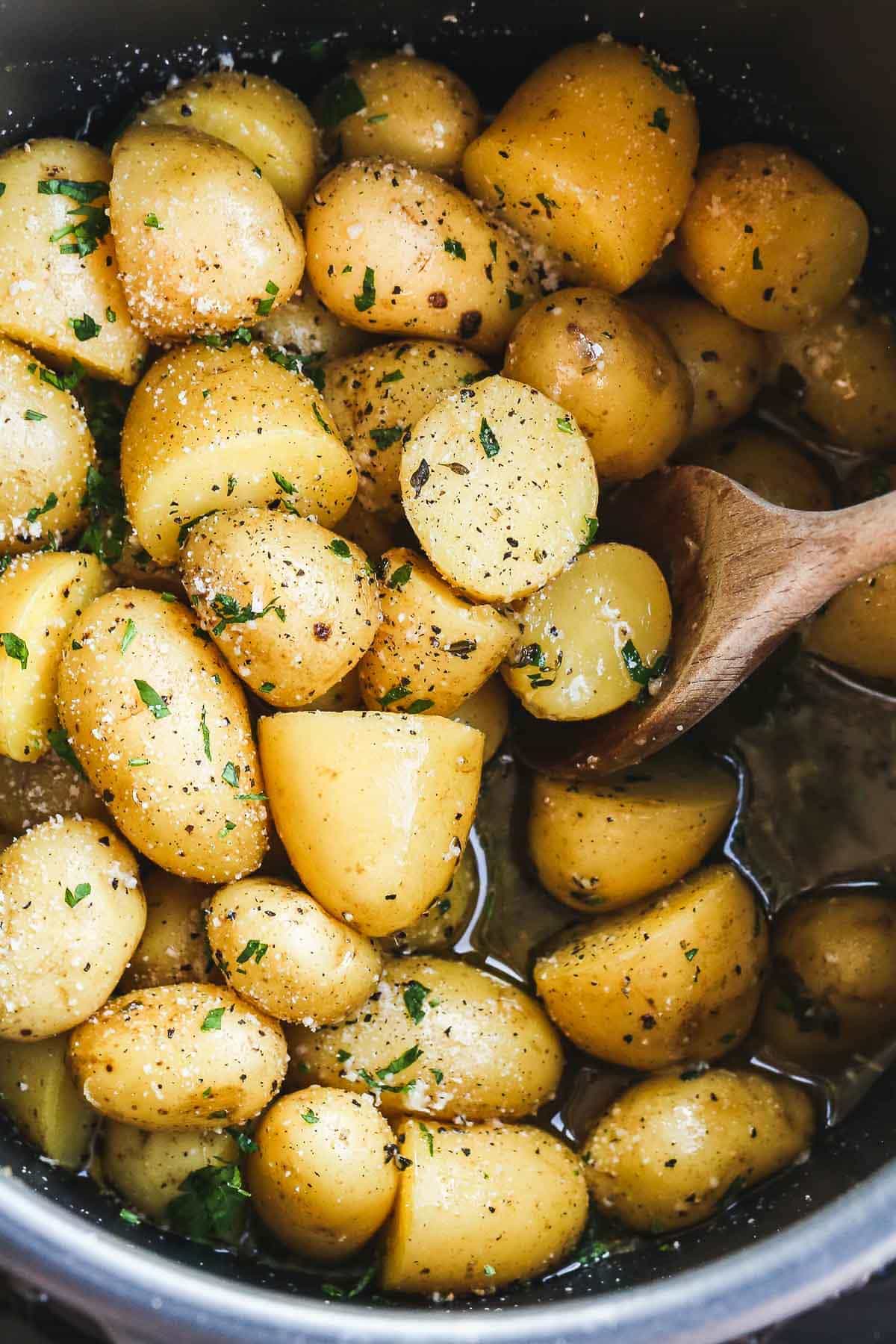 Instant pot potatoes with garlic and parmesan in the Instant Pot with a wooden spoon