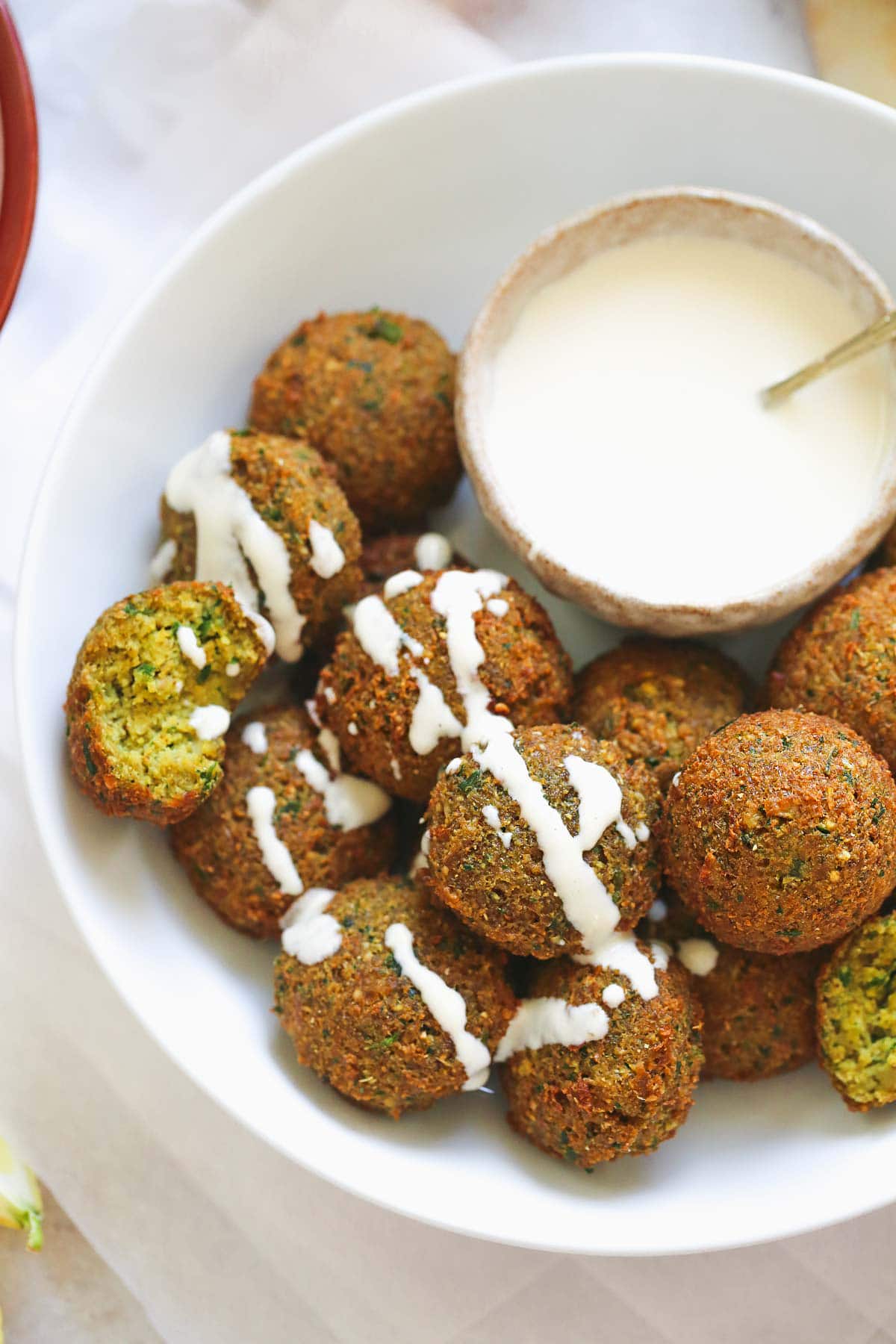 falafel with tahini sauce drizzled over the falafel balls