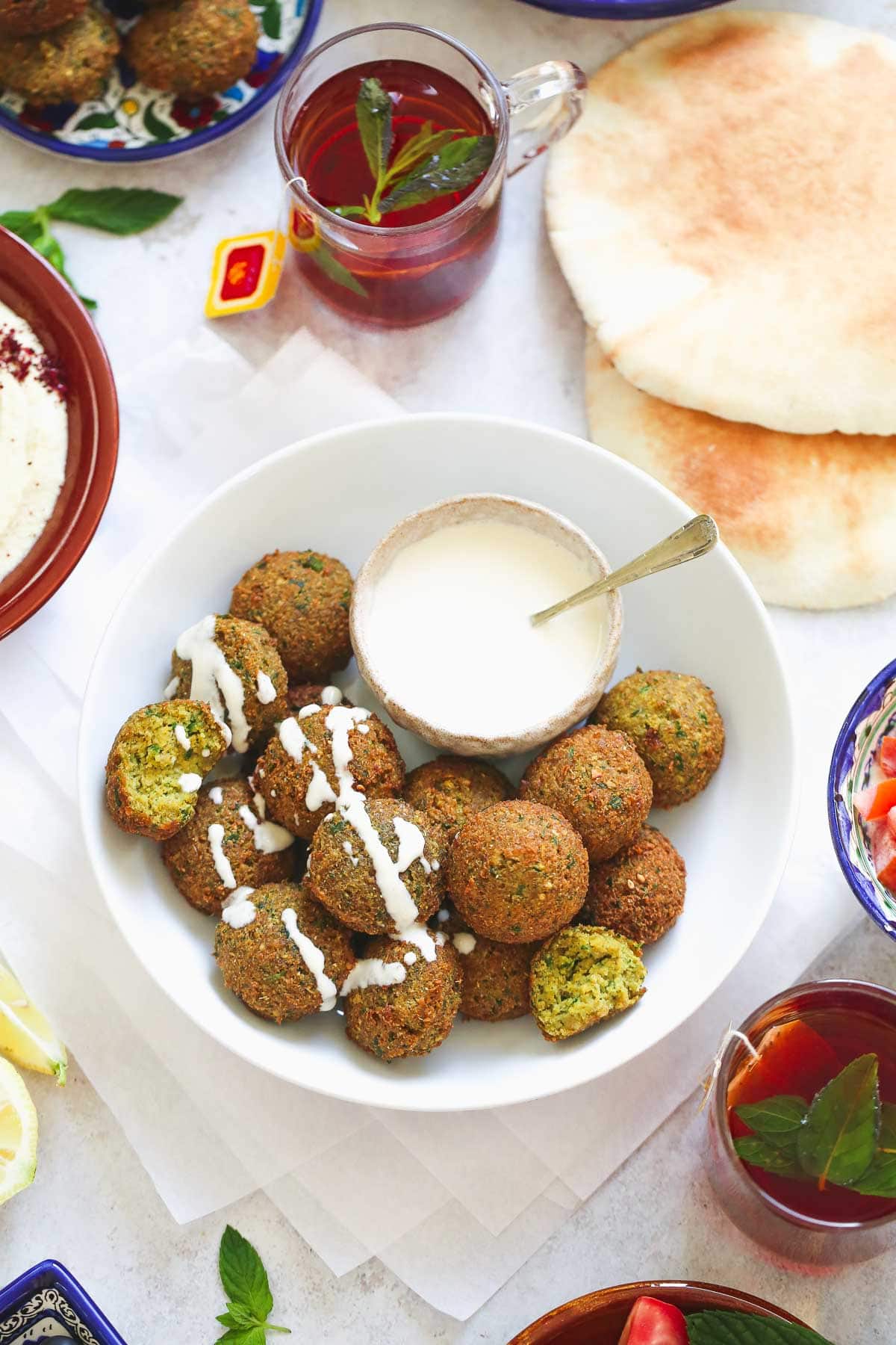 falafel spread with tahini sauce, mint tea, and pita bread.