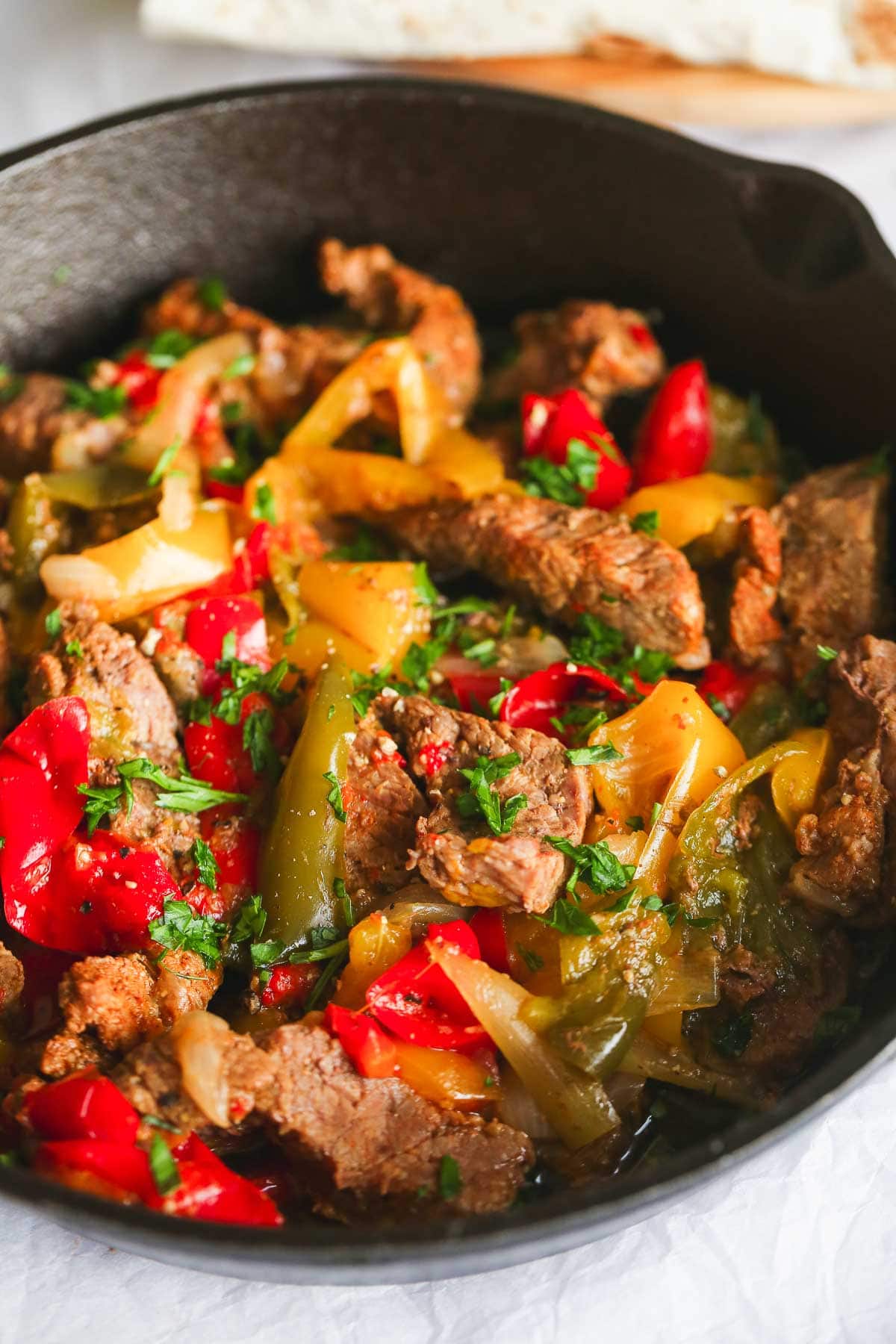 Cooked steak fajitas served in a black cast iron dish