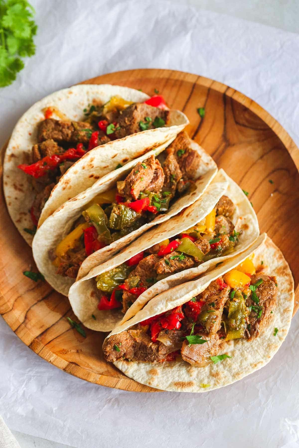 (final dish) 4 steak fajitas on a wooden tray