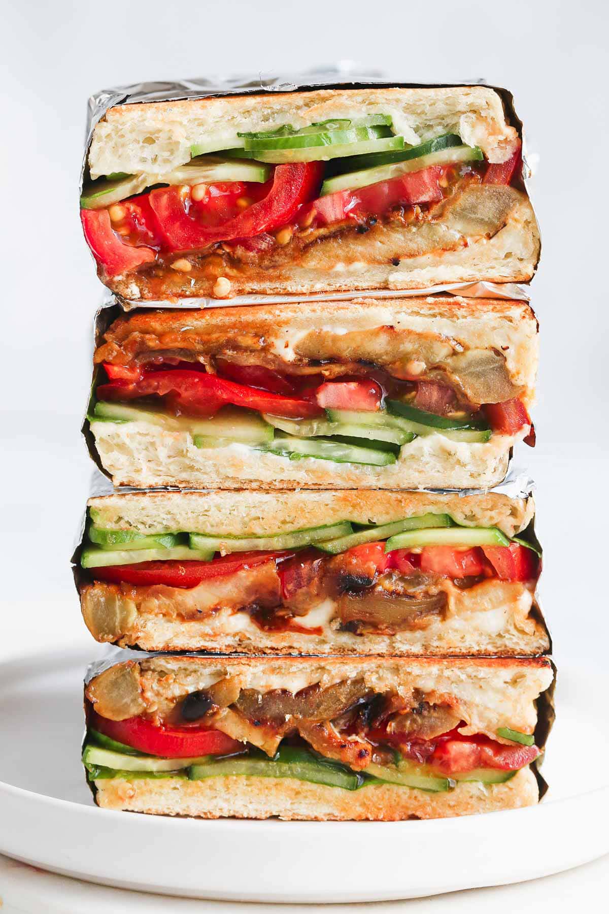 Vegan Eggplant Sandwiches stacked on a white plate