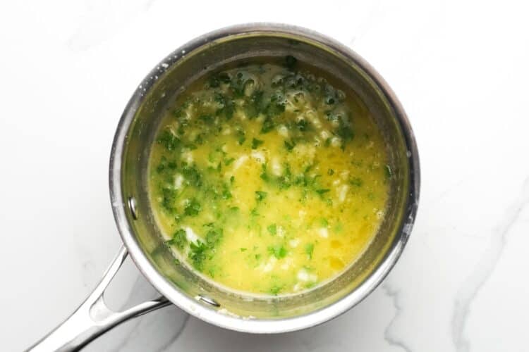 Freshly made garlic butter lemon sauce with parsley in a small saucepan.