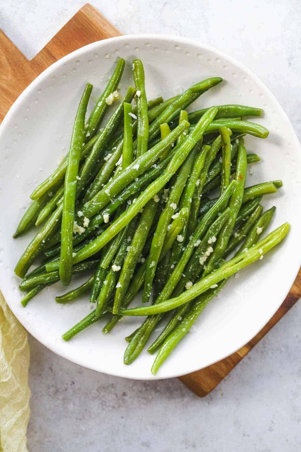 A white plate with garlic green beans
