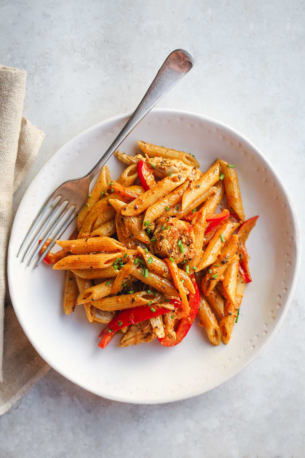 Rasta Pasta in a white plate and a fork on the side