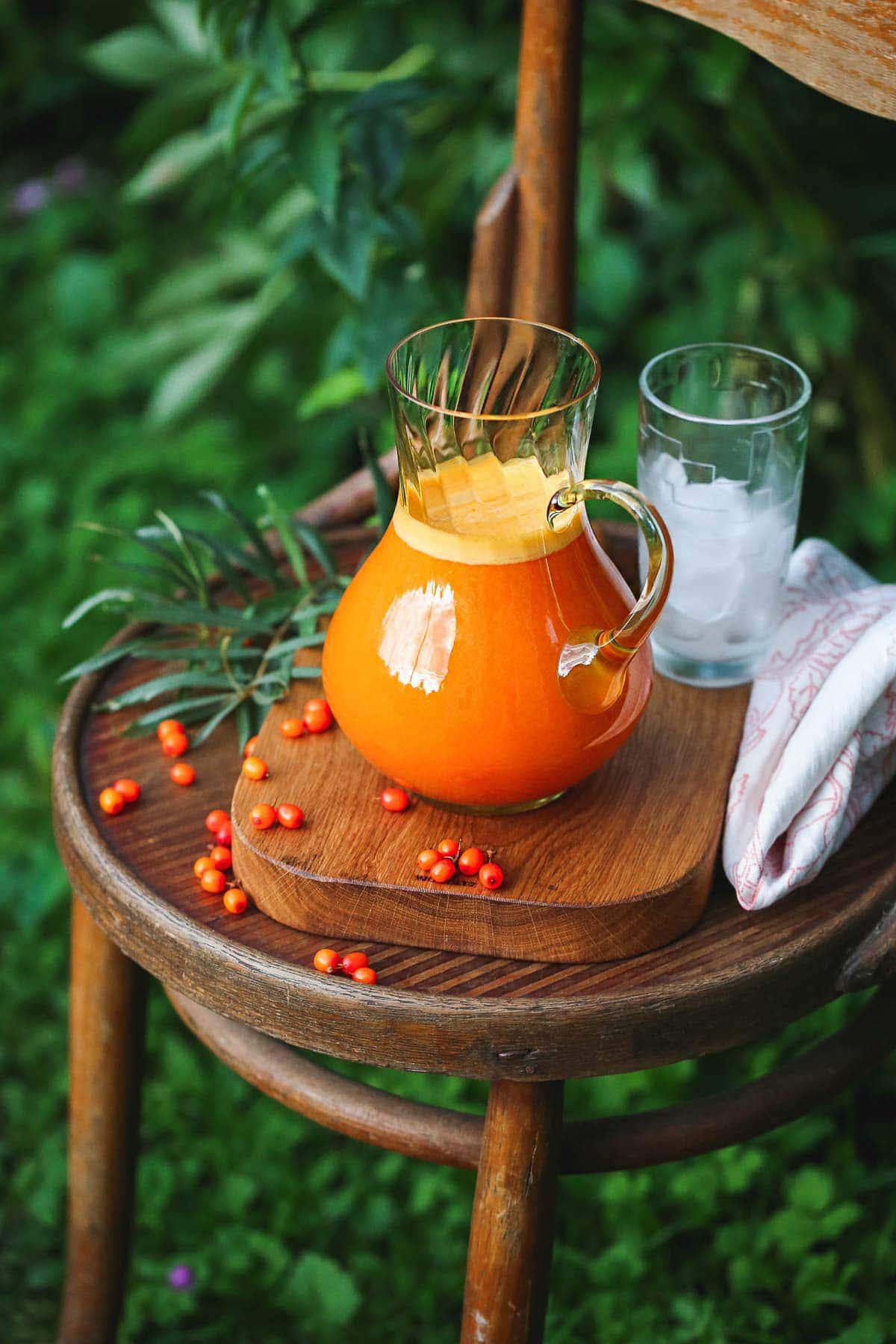 Sea Buckthorn Juice in a glass jug placed on a wooden board