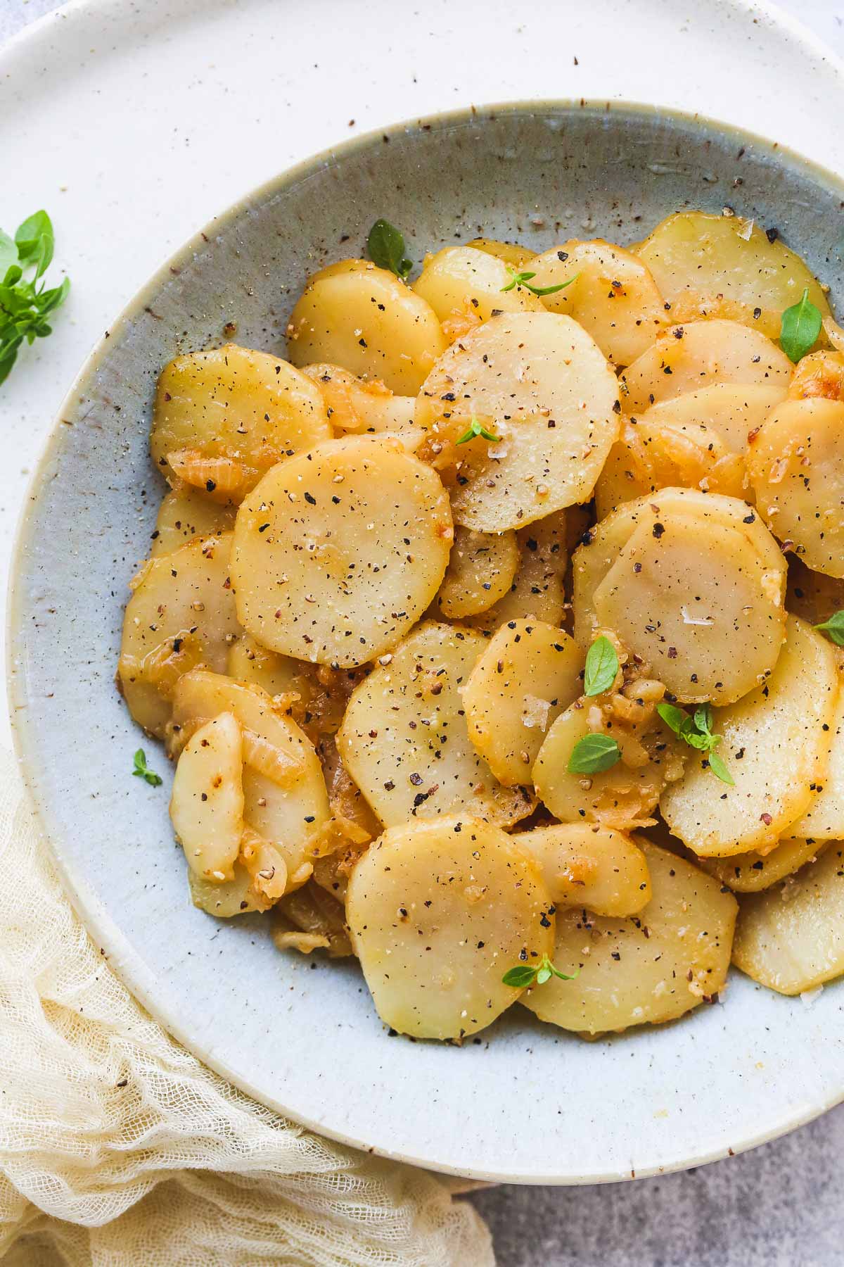 Smothered Potatoes in a bowl seasoned with black pepper. 