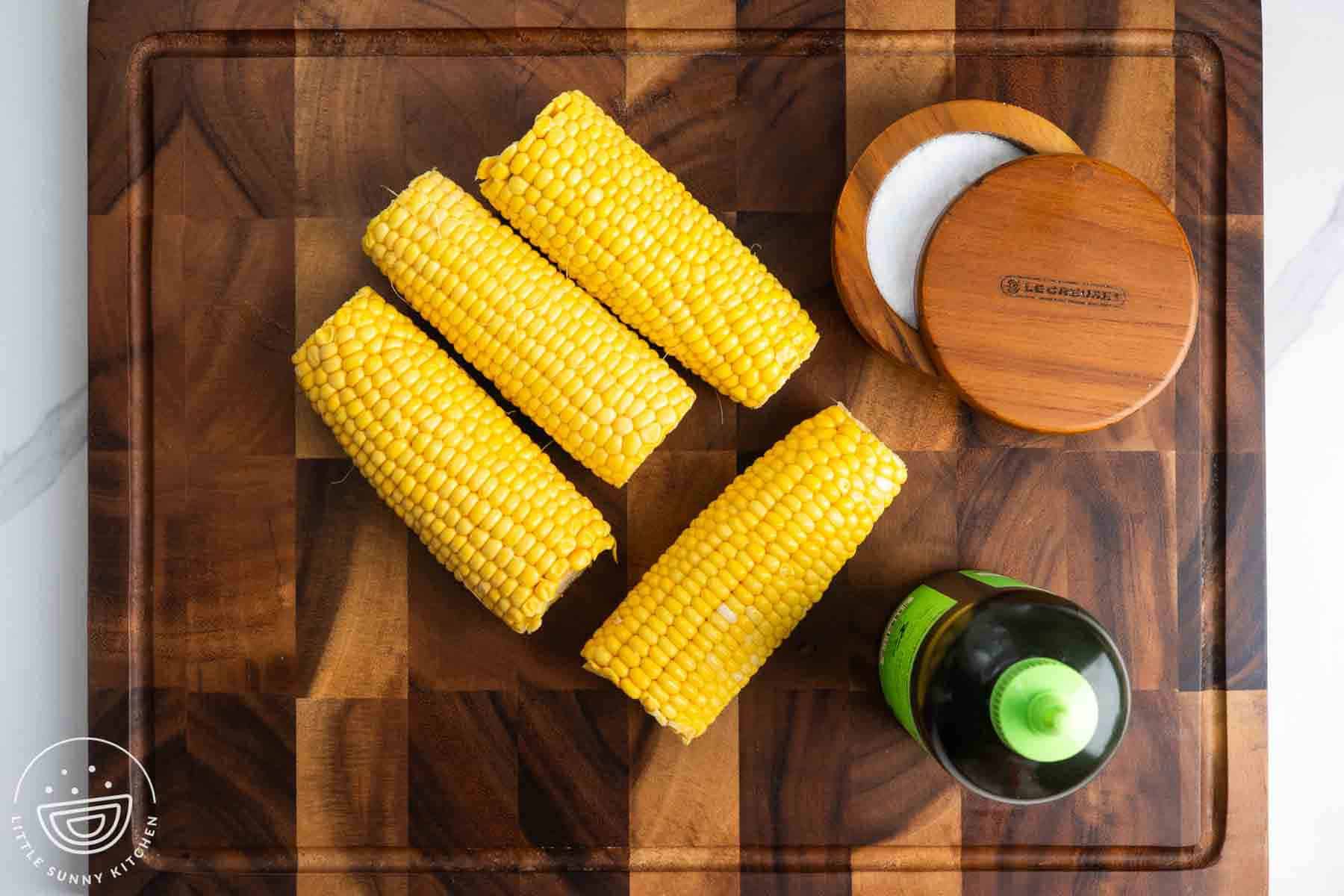 Fresh corn on the cob with olive oil and salt on a wooden board for air fryer corn