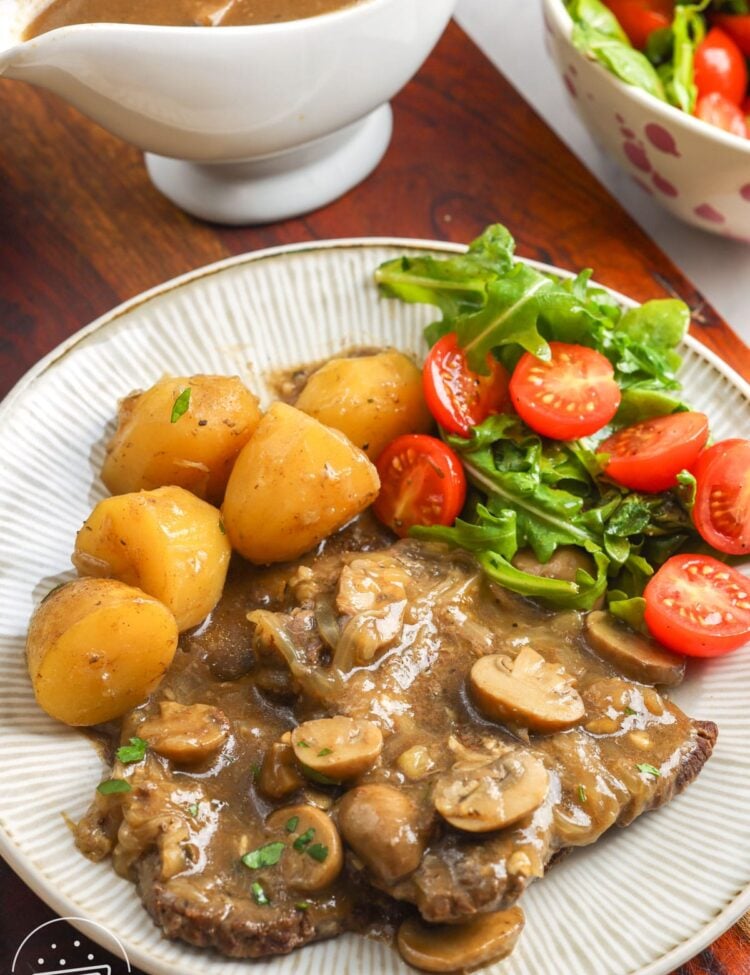 Instant Pot cube steak with mushroom and onion gravy, baby potatoes, and a fresh side salad.