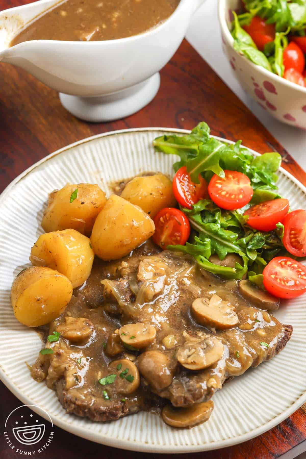 Instant Pot cube steak with mushroom and onion gravy, baby potatoes, and a fresh side salad.