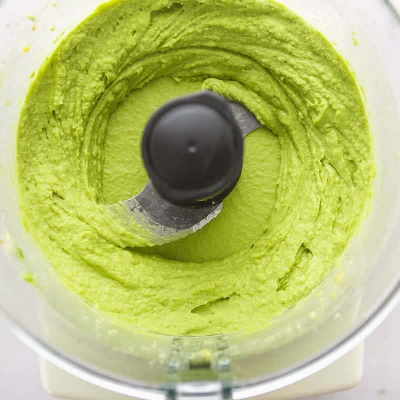 Smooth avocado hummus blended in a food processor until creamy and bright green