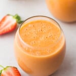 2 glasses of strawberry mango smoothie and sliced strawberries