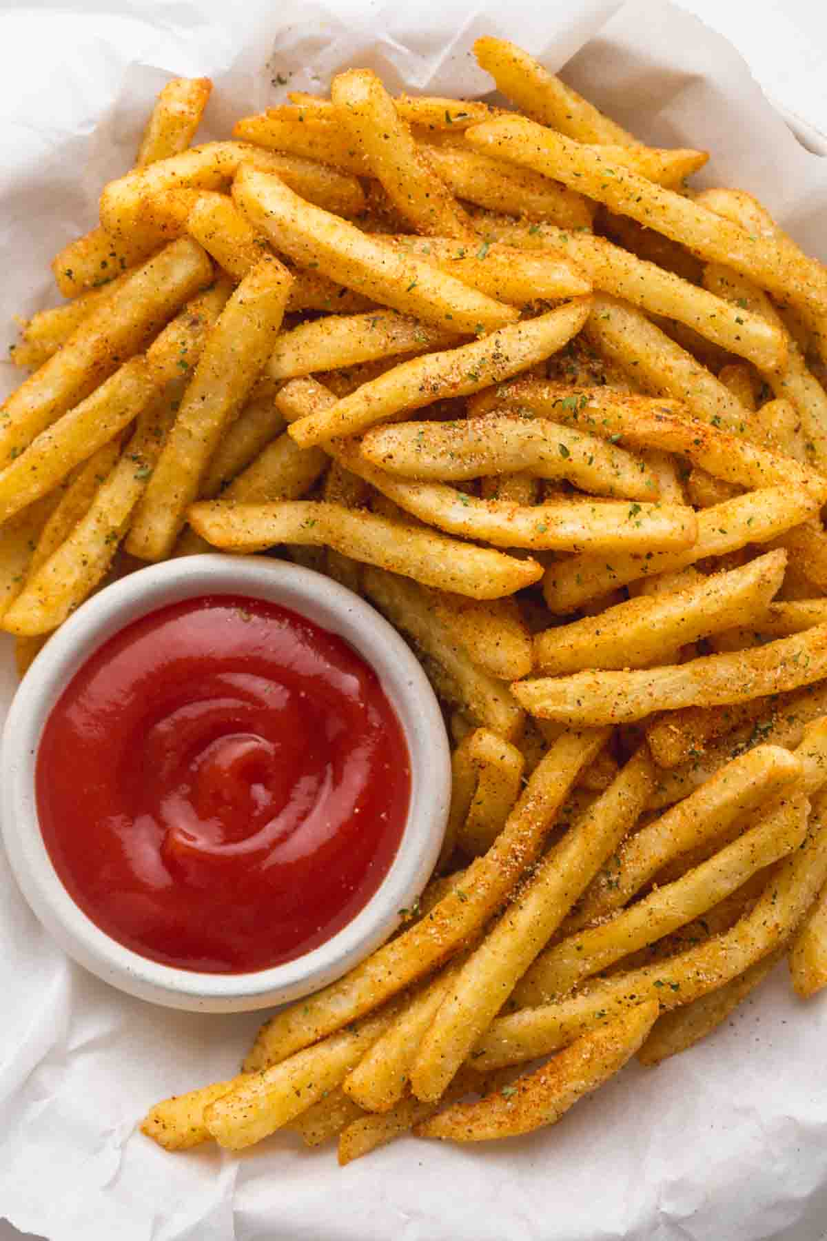 Close up of golden french fries with French Fry Seasoning and ketchup