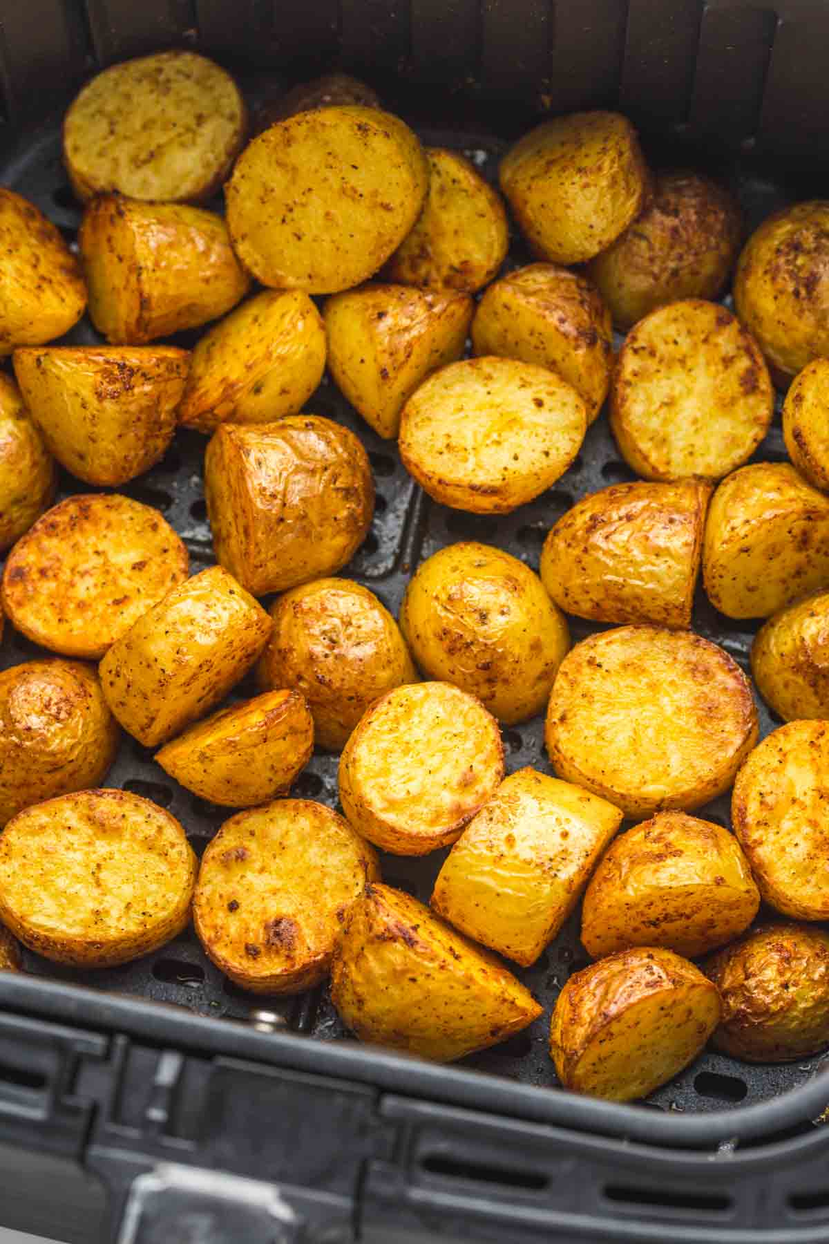 A close up of roasted potatoes in the air fryer basket