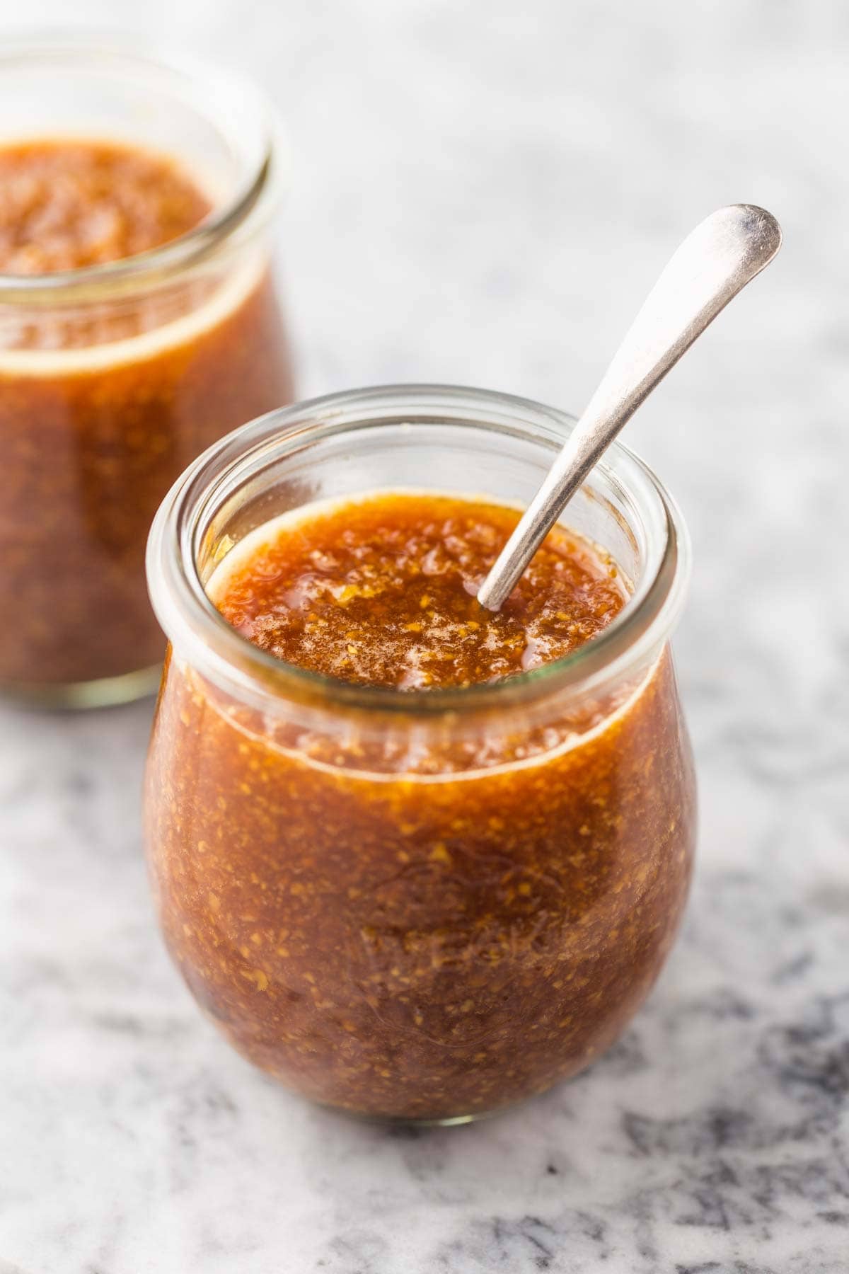 A Weck jar with ginger sauce, and a metallic teaspoon