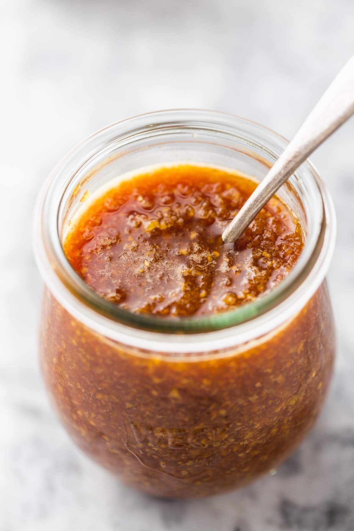 A Weck jar with ginger sauce, and a metal teaspoon