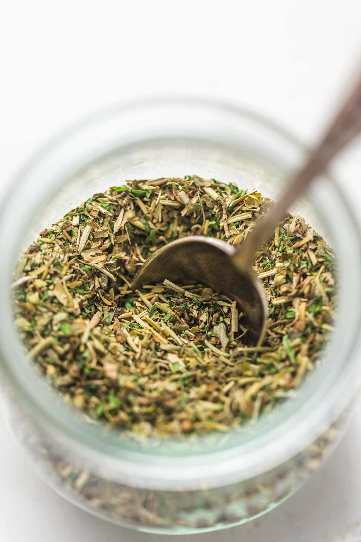 A small Weck jar with Italian seasoning and a teaspoon