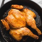 spatchcocked and roasted chicken in a cast iron pan