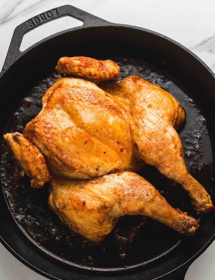spatchcocked and roasted chicken in a cast iron pan