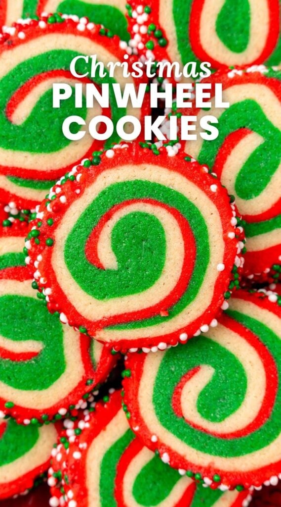 Close-up of a festive batch of Christmas pinwheel cookies featuring red, green, and white swirls, coated with red, green, and white sprinkles, with bold text overlay reading 'Christmas Pinwheel Cookies.'