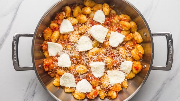 gnocchi in tomato sauce topped with mozzarella and parmesan