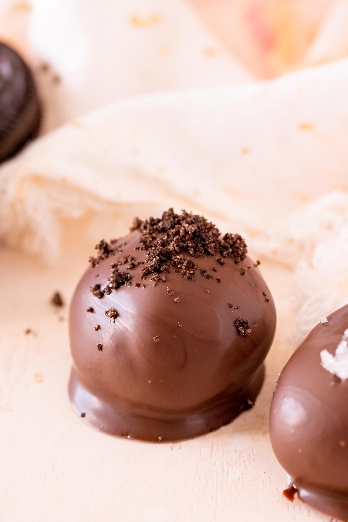 A close up of an Oreo truffle topped with Oreo crumb
