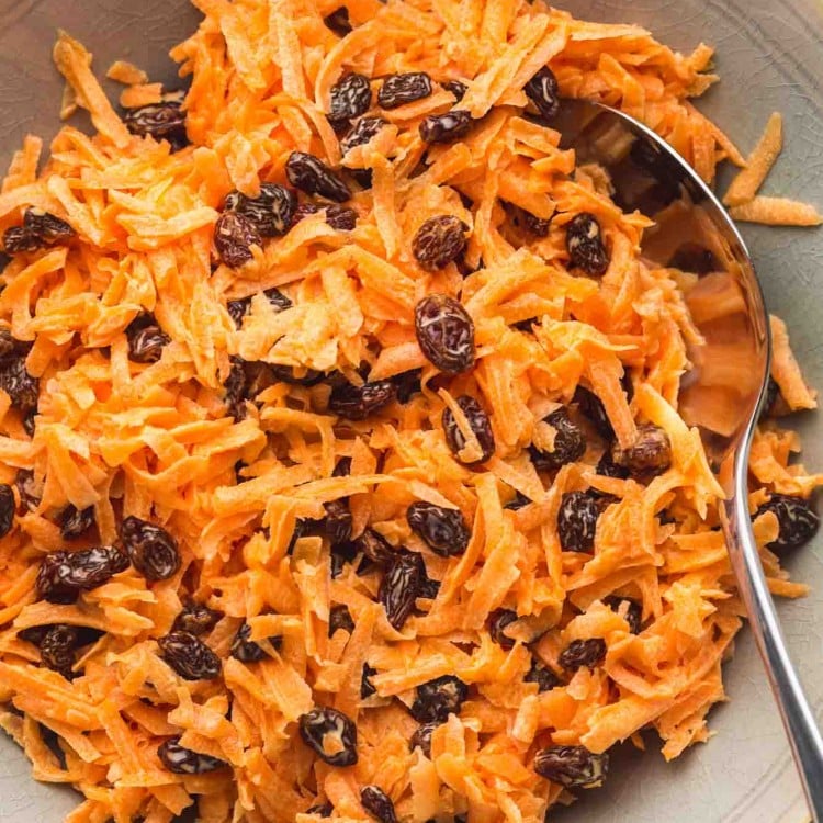 Carrot Raisin salad served in a large bowl, and a serving spoon