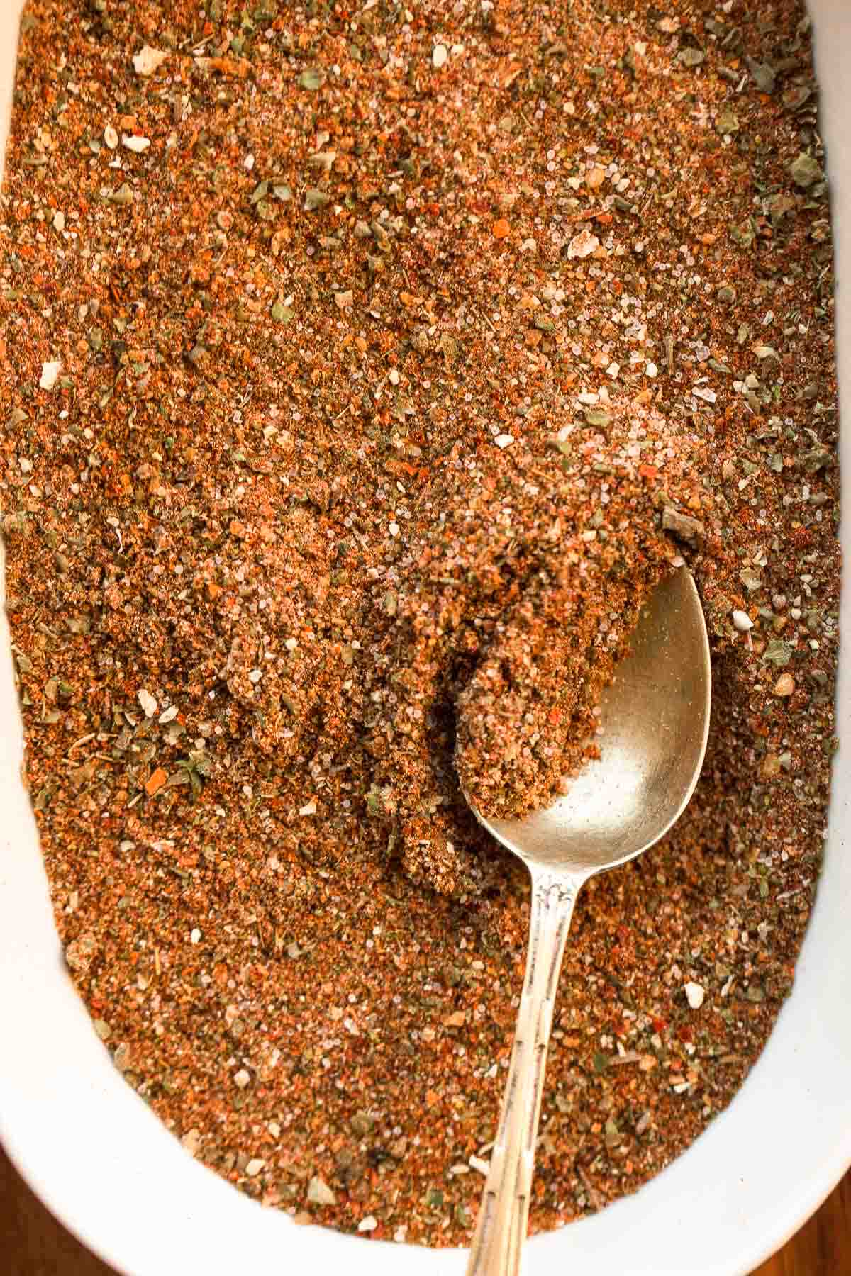 A close up shot of the taco seasoning in a bowl with a metallic teaspoon