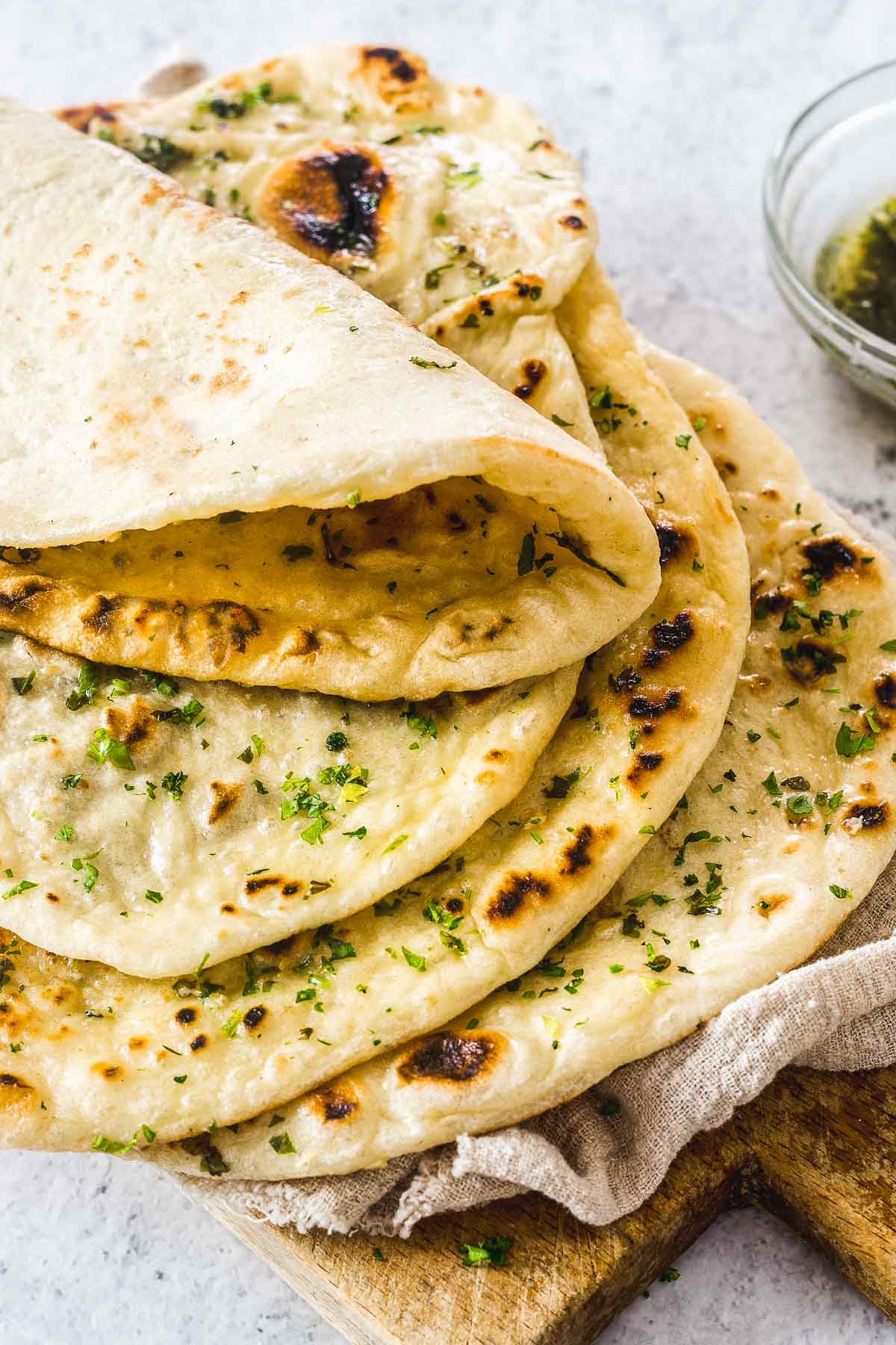 4 naan breads stacked on each other, and brushed with herb butter.