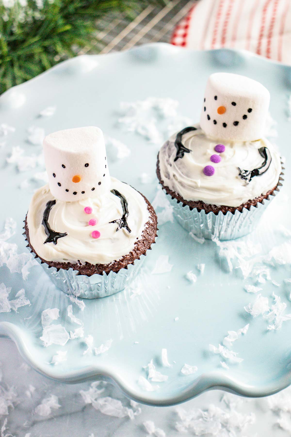 2 snowman cupcakes on a cake stand