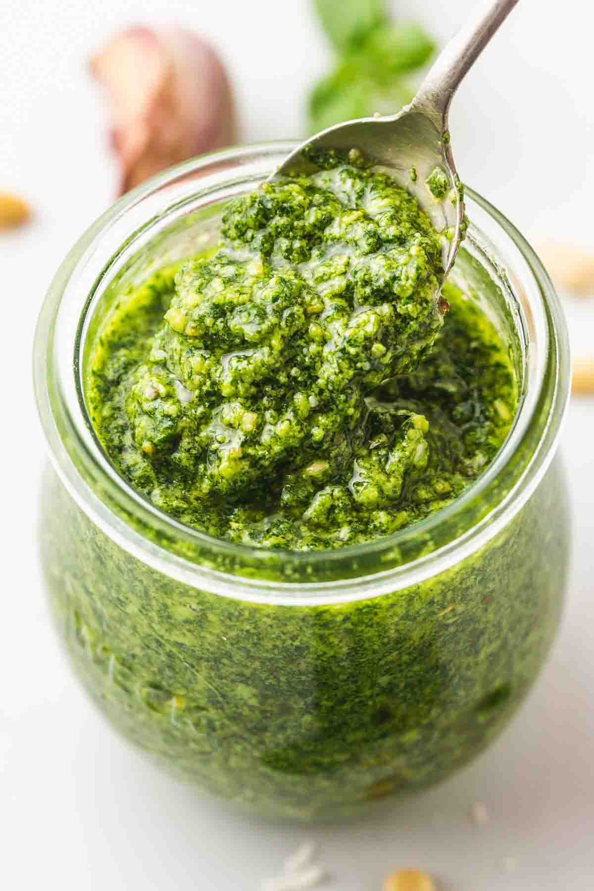 A weck jar with fresh green pesto and a spoon
